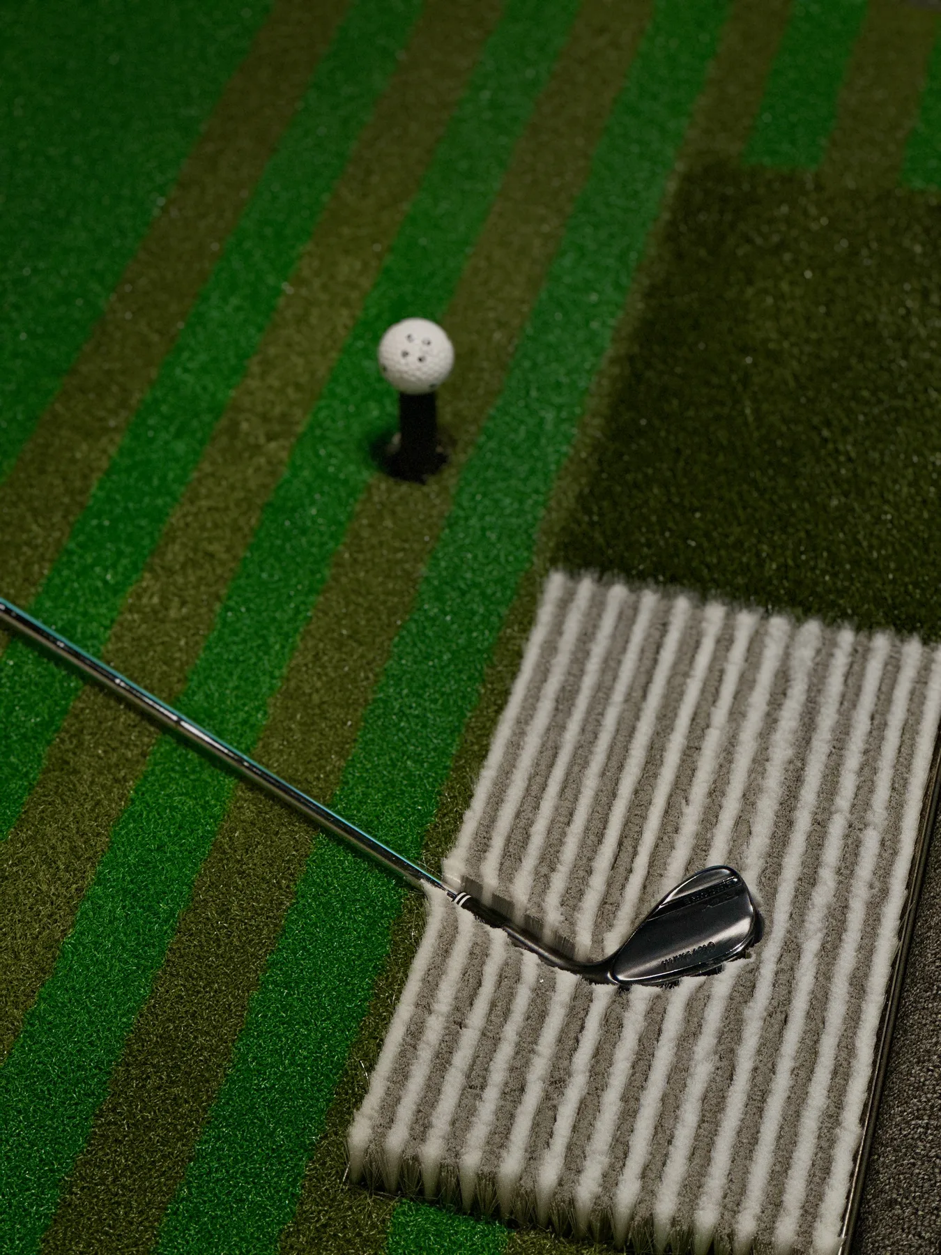 Golf ball on the tee inside the simulator bay