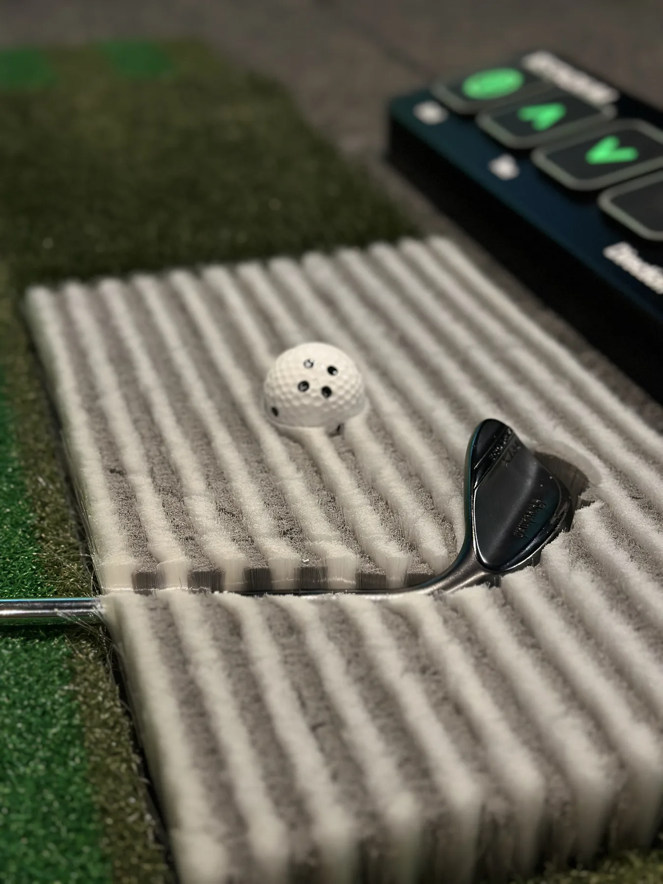 Golf club, ball, and brush mat detail inside the bay